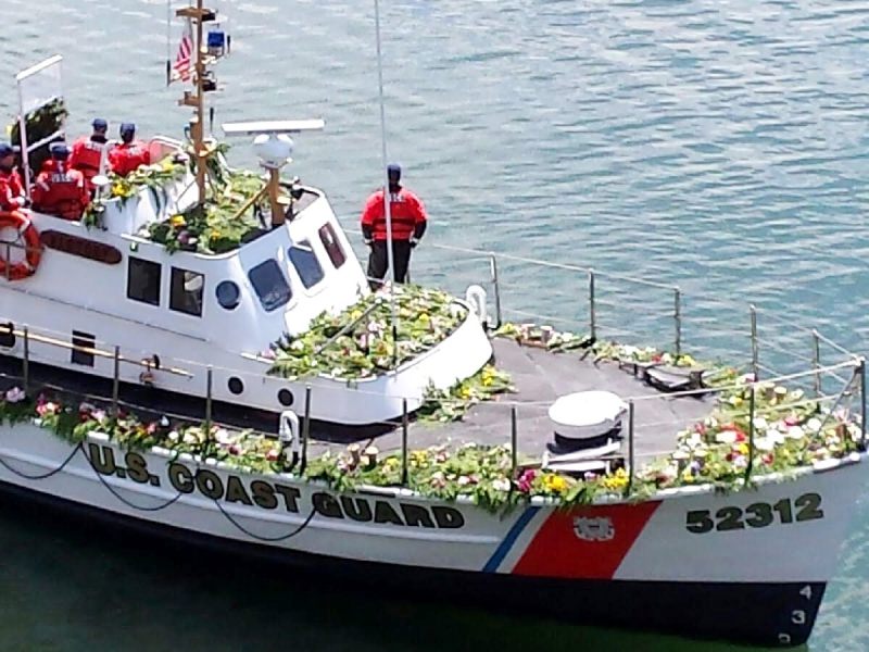 A Coast Guard boat with memorial wreaths